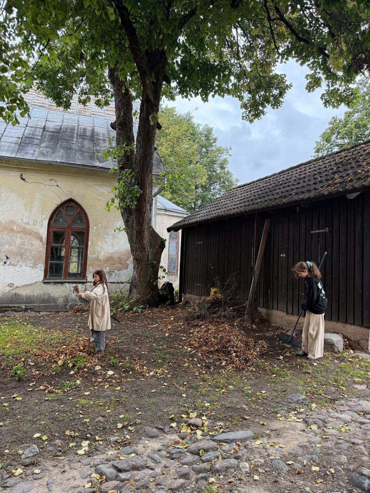 Children raking leaves in the churchyard